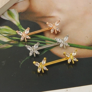 Macro view of three dragonfly nipple rings in gold, silver and rose gold with zircons