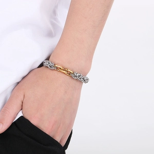 Détail d'un bracelet de style urbain avec maille argentée et maillons ovales dorés