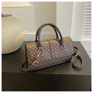 Detail of vintage brown crossbody bag with geometric prints and gold hardware