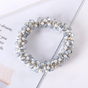 Detailed view of elegant hair tie with light blue crystal beads and white pearls