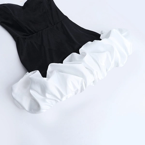 Détail de la robe bustier en velours avec ourlet à volants blancs contrastés