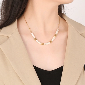 Elegant gold-plated titanium steel necklace with white beads worn by a model