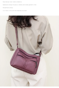 Detailed back view of a purple textured leather crossbody bag with multiple zippers