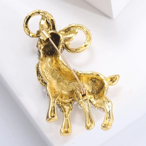 Detail view of the golden metal back and pin clasp of the pearl sheep brooch