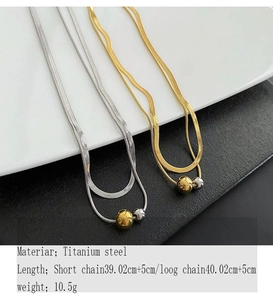 Detail view of gold and silver titanium steel ball pendants on flat snake bone chains