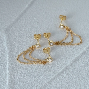 Detail of 925 sterling silver gold earrings with chain tassels and crystal studs