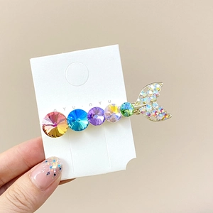 Detail of mermaid tail hair clip with multi-colored crystals and sparkling rhinestones