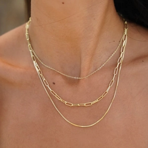 Close-up of triple-layered 18K gold stainless steel necklace on model neck