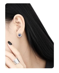 Detail of silver earrings with lapis lazuli and textured wide silver ring on a model