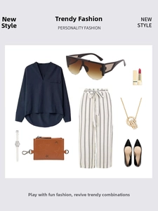 Flat lay of stylish brown gradient sunglasses styled with an elegant navy blue v-neck outfit