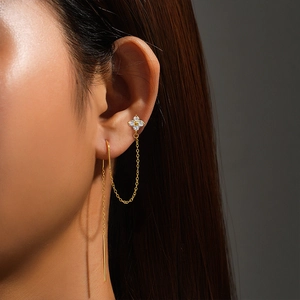 Close-up of gold s925 silver fringe earring with sparkling cz clover on model ear
