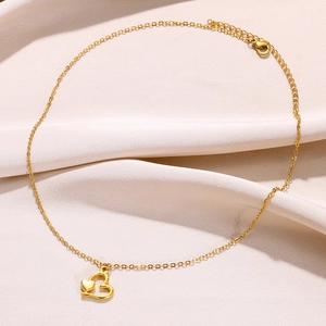 Gros plan détaillé d'un collier doré double cœur sur un fond de soie beige doux