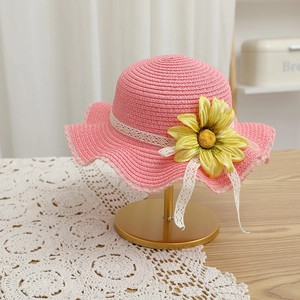 Chapeau de paille rose orné d'un tournesol jaune et de rubans en dentelle blanche