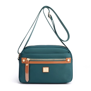 Waterproof dark green nylon crossbody bag for women with brown leather accents and gold hardware