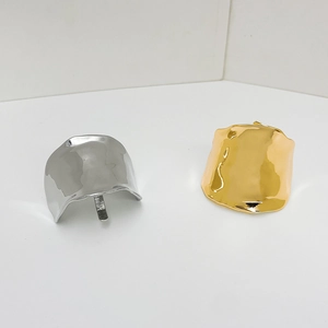 Detail of wavy textured gold and silver metal rings showing polished abstract wide surface
