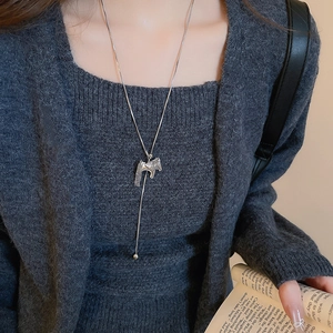 Close-up of vintage silver trojan horse pendant necklace with elegant tassel details