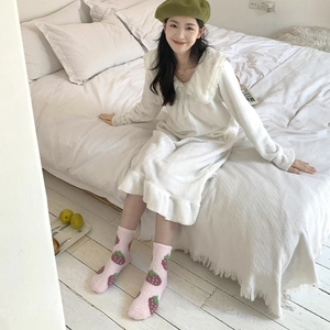 Detail of pink strawberry pattern coral fleece socks paired with a white flannel sleep dress