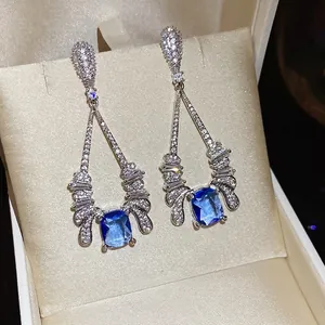 Silver needle drop earrings with rectangular blue sapphire and sparkling zircon accents