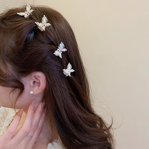 Set of four butterfly hair clips with pearls and crystals shown on model's hair
