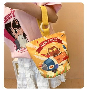Detail of cute cat pilot illustration on an orange canvas bucket bag with yellow handle