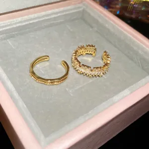 Elegant 18k gold plated adjustable rings with cubic zirconia stones on velvet display