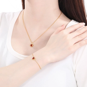 Parure de bijoux en acier doré 18 carats avec cœurs rouges sur un mannequin