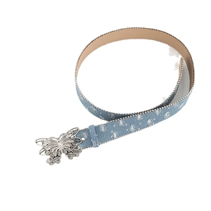 Blue denim canvas belt with silver butterfly buckle and rivets on white background