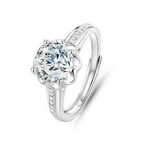 Macro view of four-prong silver ring with a large clear center stone and paved side gems