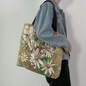Close-up of floral jacquard woven canvas tote bag with large daisy patterns and black handles