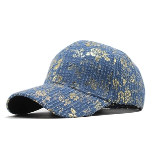 Detail of blue denim baseball cap with premium gold floral foil print patterns