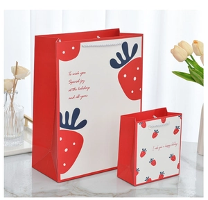 Detail showing red and beige cartoon gift bags in two sizes on a marble surface
