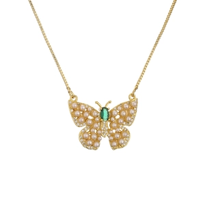 Golden butterfly necklace with pearls and green gemstone on a polished chain