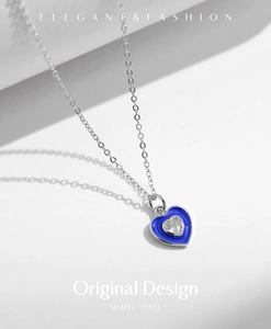 Macro detail of S925 silver heart necklace with blue enamel and sparkling zircon