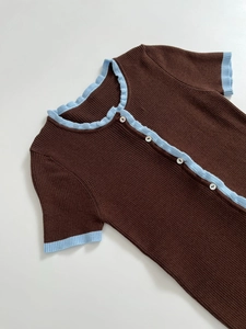 Detail of slim fit knit cardigan with contrast ruffles and small white buttons
