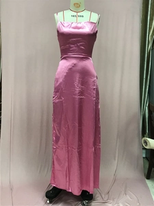 Détail d'une robe de soirée en satin rose montrant les bretelles et le tissu soyeux