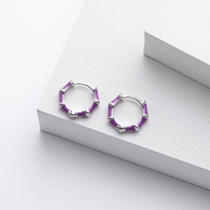 Detail shot of purple enamel bamboo joint hoop earrings on a white display stand