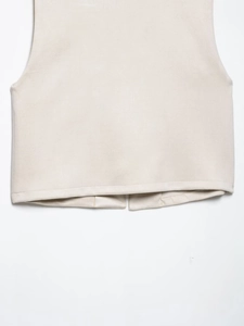 Detailed close-up of the beige suede vest hem featuring high-quality embroidery texture