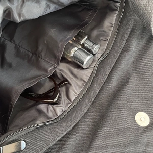 Interior detail of black canvas shoulder bag with dual pockets and magnetic closure