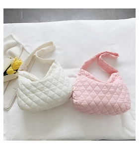 Detail of white and pink quilted puffer shoulder bags with soft down fabric texture