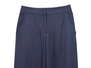 Vue détaillée du pantalon bleu foncé présentant une texture sergée et des détails à la taille
