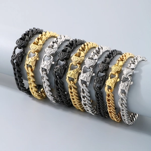 Polished stainless steel Cuban link bracelets in gold, silver, and black on a display stand