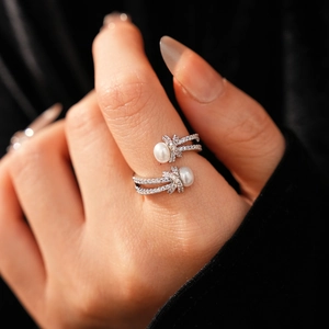 Close-up of double-layered silver ring with white pearls and pavé zircon knot details