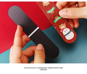 Close-up of Christmas magnetic bookmark unfolding into a cute festive fridge magnet