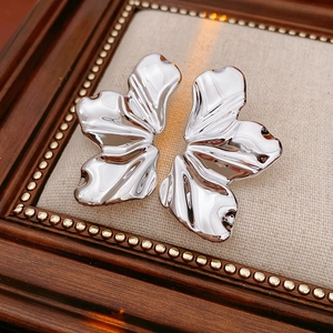 Detailed view of silver irregular leaf earrings with a polished metallic mirror finish
