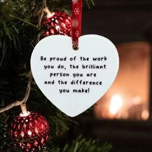 Flat acrylic heart ornament with red snowflake ribbon hanging on a Christmas tree