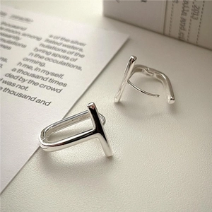 Minimalist 925 sterling silver T-shaped stud earrings on a vintage paper background