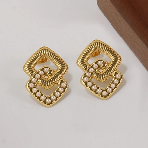 Macro detail of double-layered geometric gold stud earrings with inlaid pearls