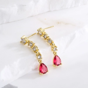 18K gold plated teardrop ruby earrings with sparkling zircon tassels on marble background