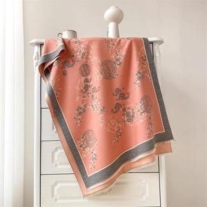 Détail d'une écharpe en cachemire corail avec motifs chinois traditionnels et glands doux