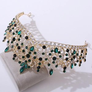 Detailed view of bridal crown with green and black crystals on a beige suede stand